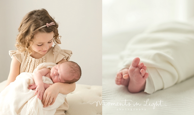 Young girl holding baby brother by newborn photographer in The Woodlands