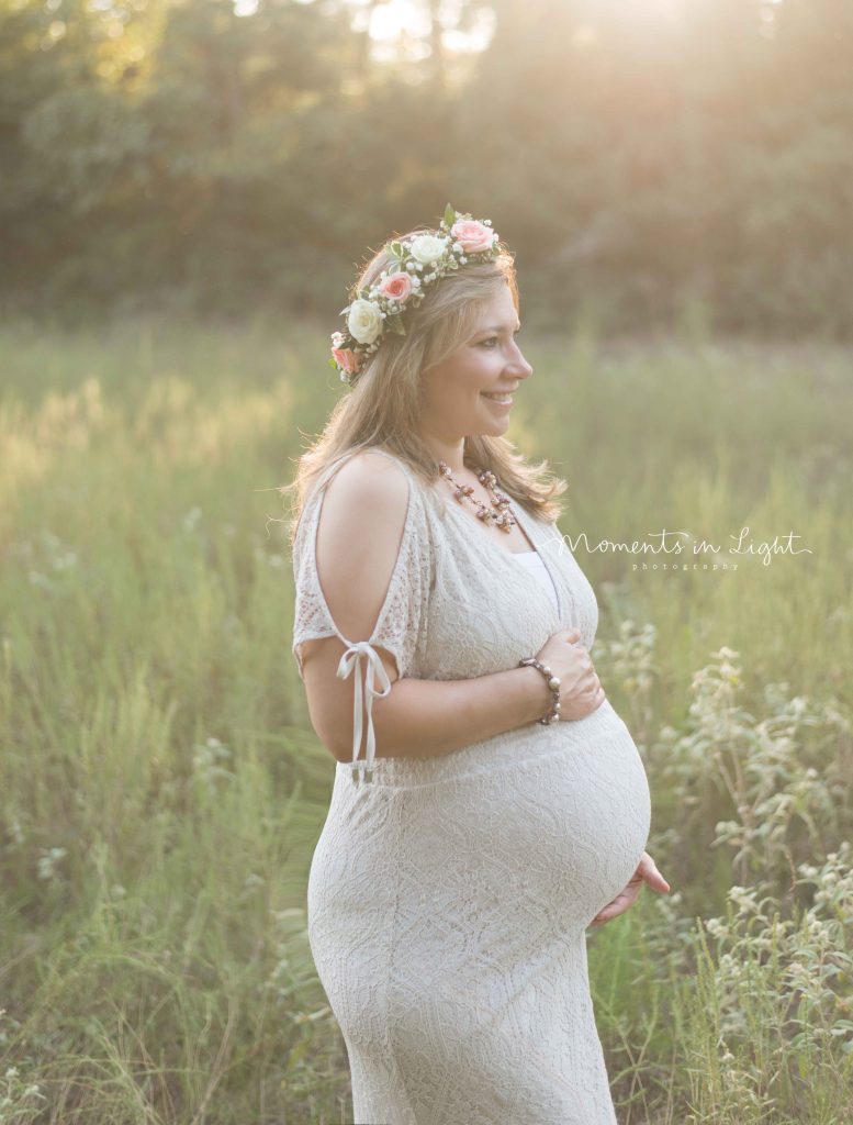 pregnant woman in a field at sunset with floral crown