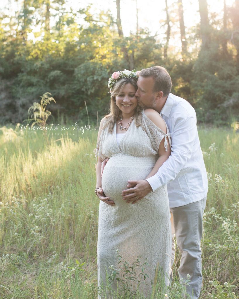 maternity photo of woman in field at sunset with husband 