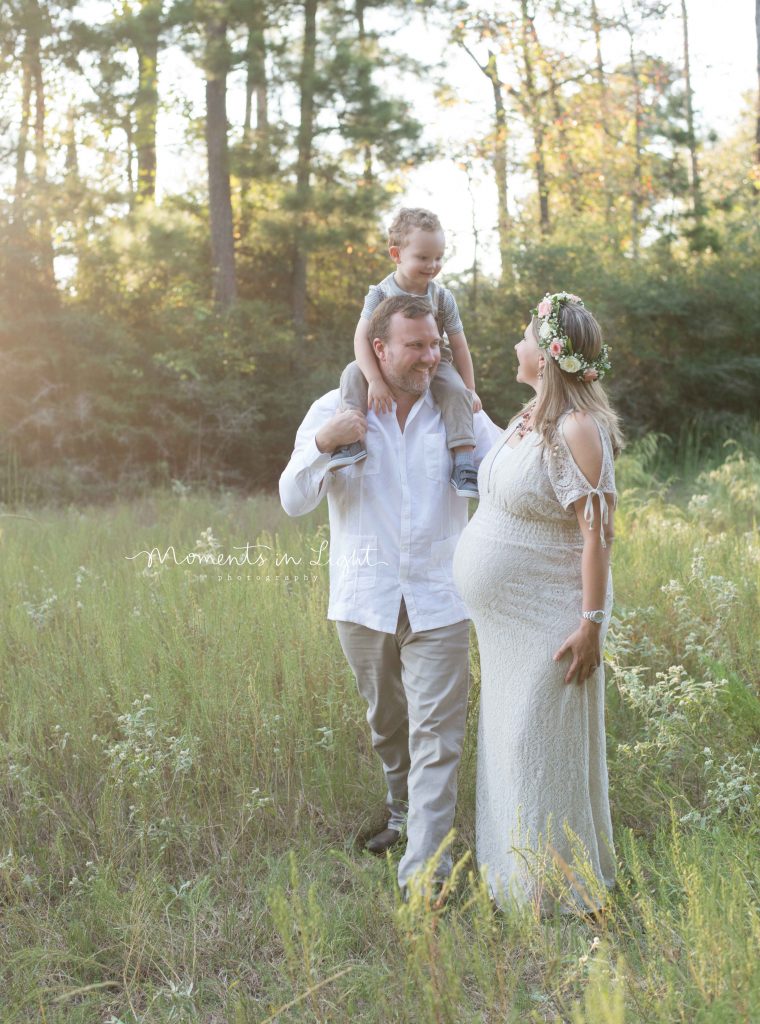 maternity photo of mother with husband and young son in a field in The Woodlands, TX at sunset 