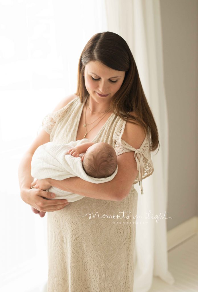 mother with newborn baby by window 