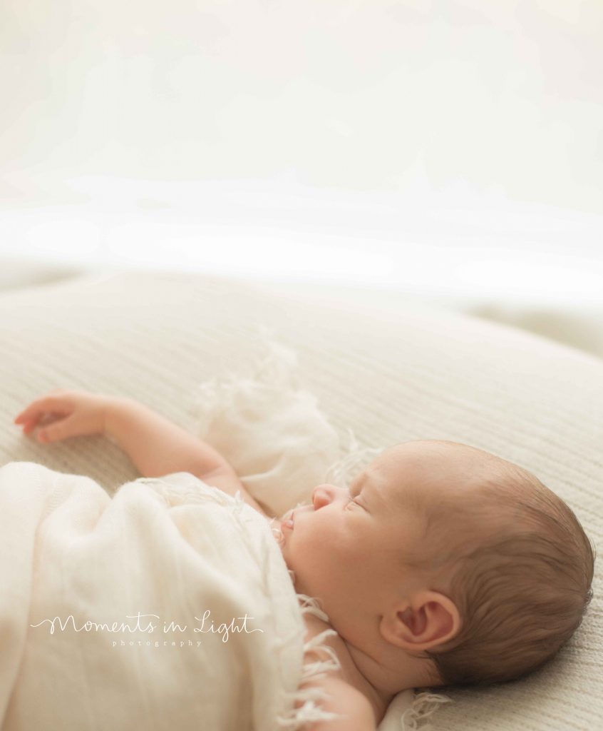 newborn baby by window light in The Woodlands