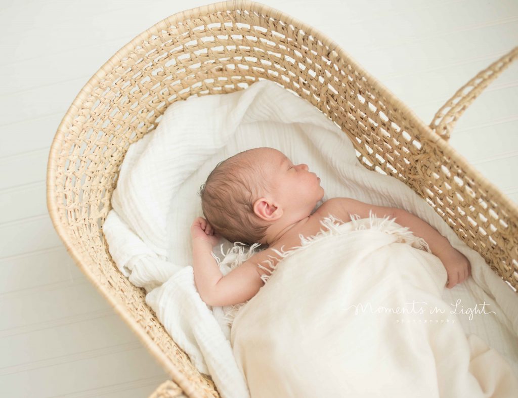 newborn baby in moses basket in The Woodlands, TX