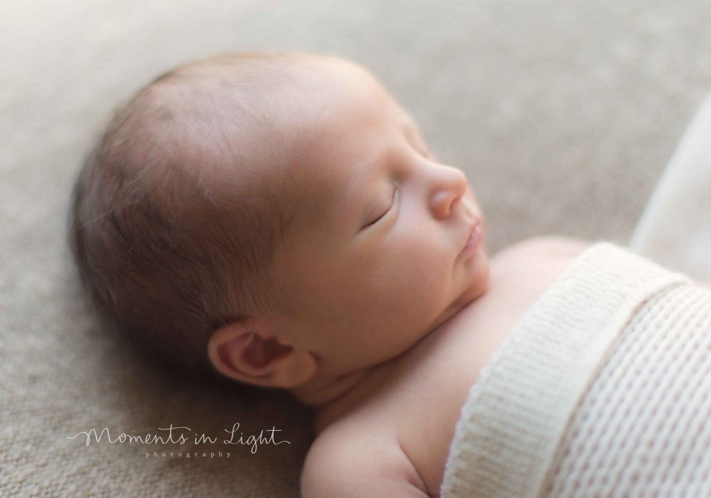 newborn baby boy in cream blanket in Houston newborn photography studio 