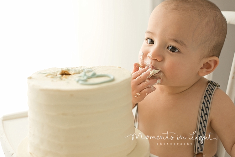 Baby boy eating cake in Houston baby photography studio