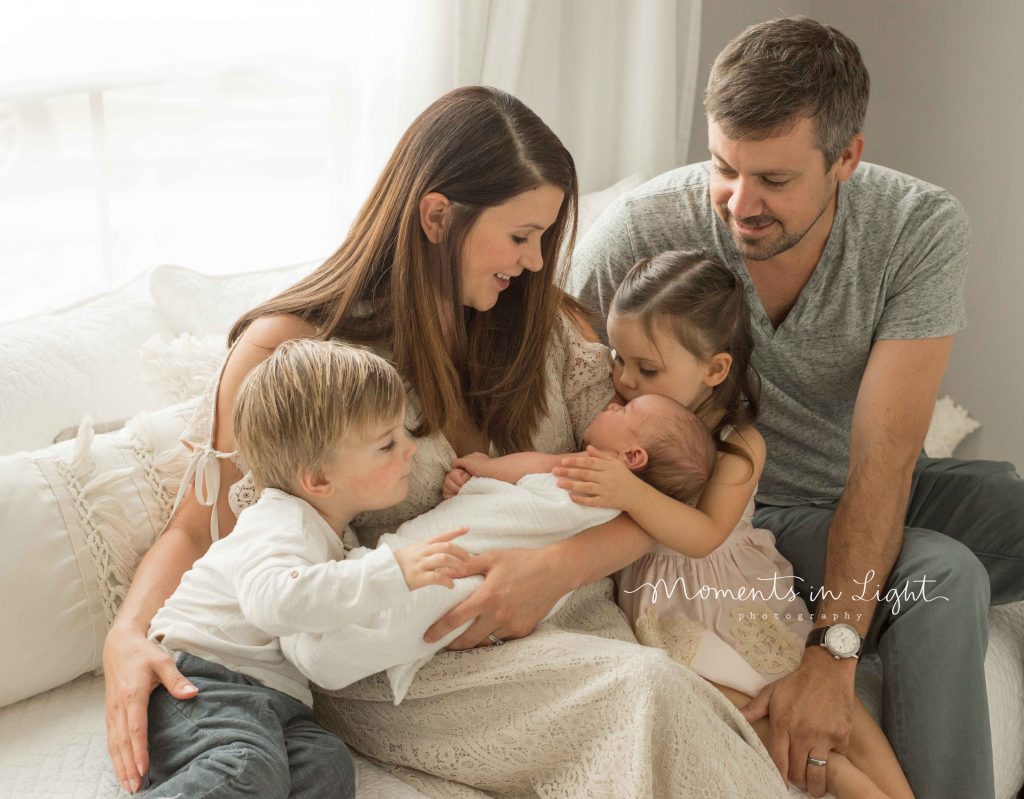 family with two toddlers and newborn baby all smiling