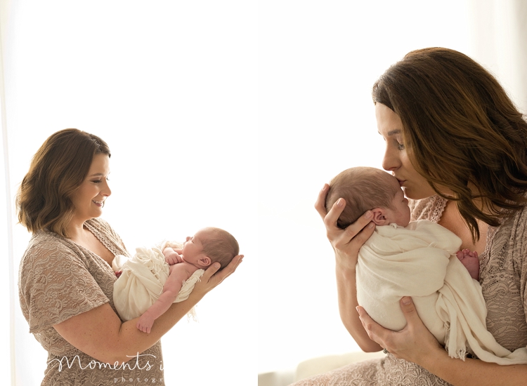 Swaddled baby being kissed on the head by newborn photographer in The Woodlands