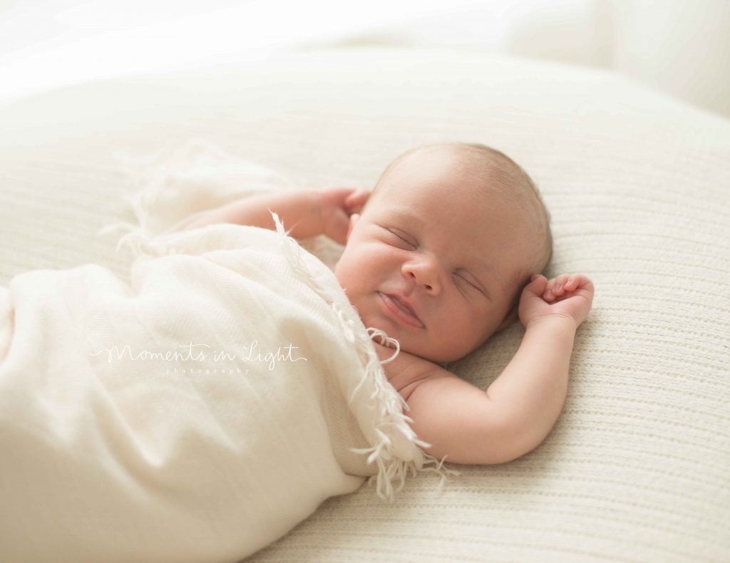 smiling newborn baby in The Woodlands photo studio