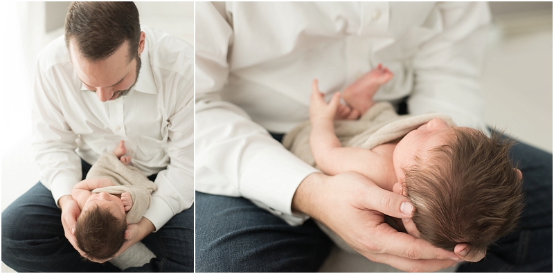 A new daddy holds his baby in his hands. 