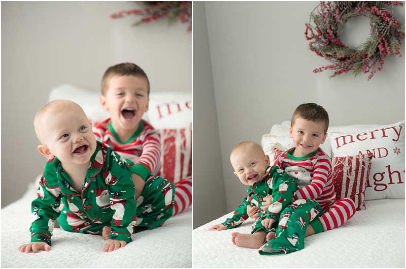 Two boys sit on a bed during a Studio Child Photography session at Christmas. 