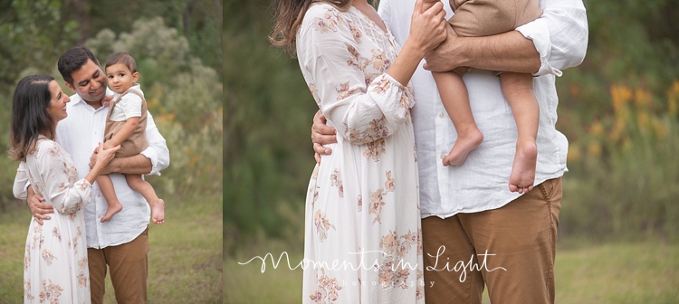 Mother and father holding baby boy in a field by Houston family photographer