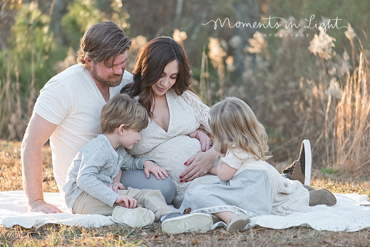 Pregnant mother with husband, son and daughter all touching her belly by Houston maternity photographer