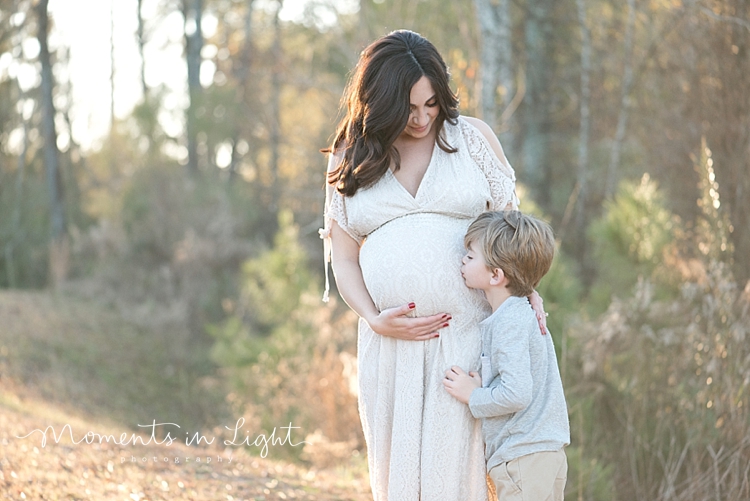 Young boy kissing pregnant mother's belly by maternity photographer in Montgomery, Texas