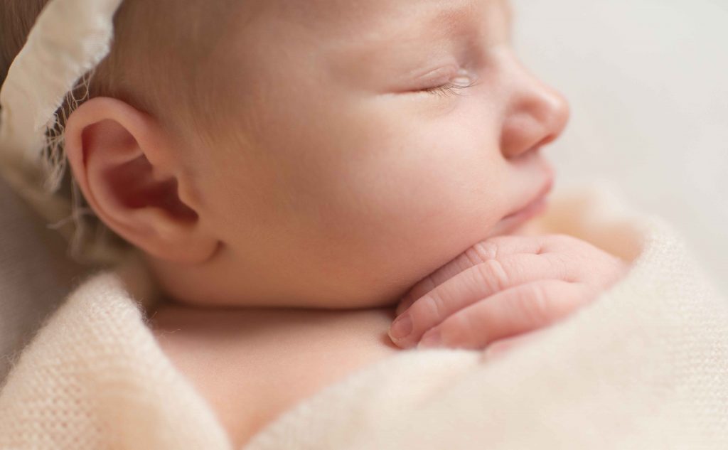 close up of newborn baby eyelashes and fingers 