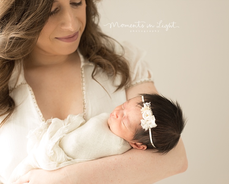 A mother holds her baby girl newborn. 