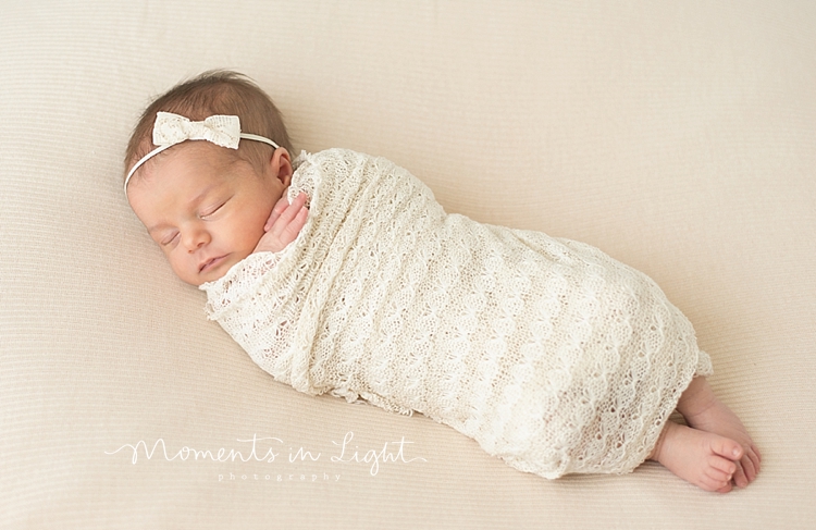 A small baby girl sleeps through her family with newborn photography session. 