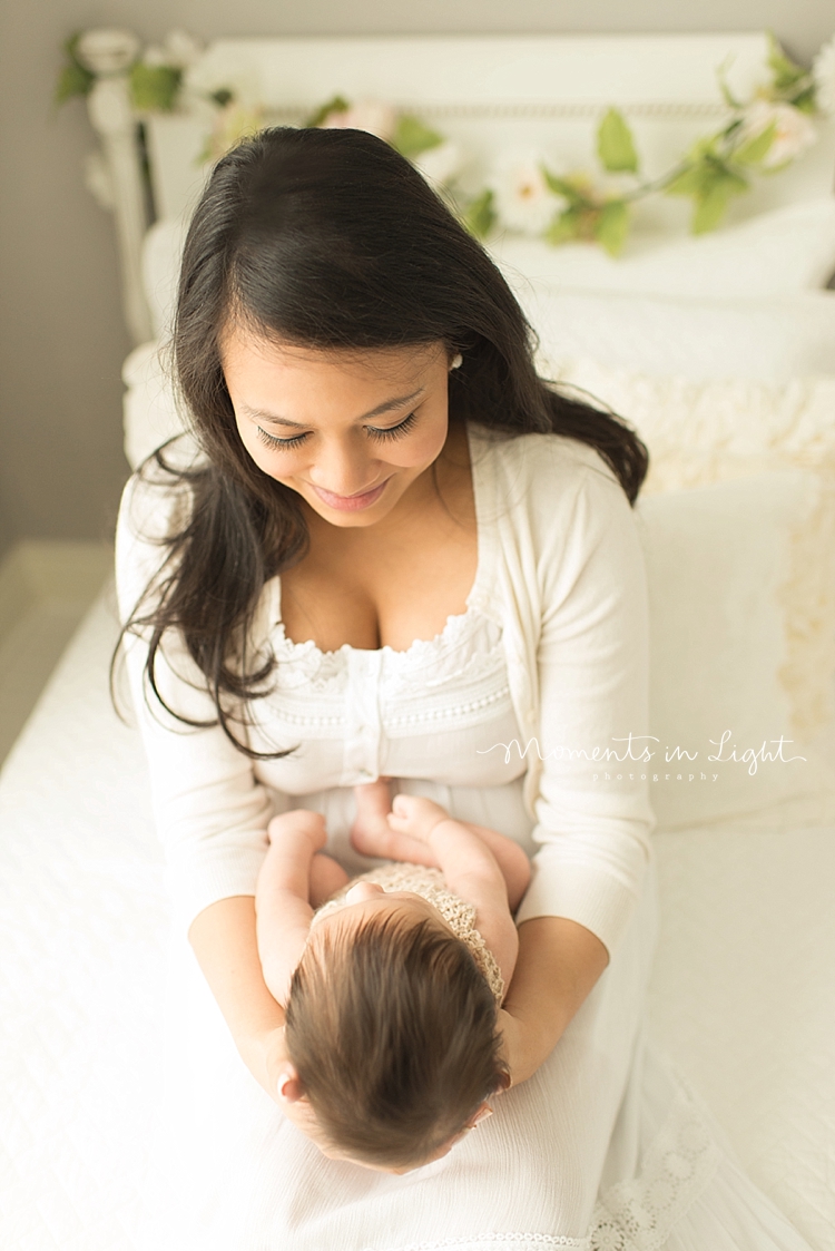 Moments in Light Photography captures a mom talking to her newborn while holding her. 