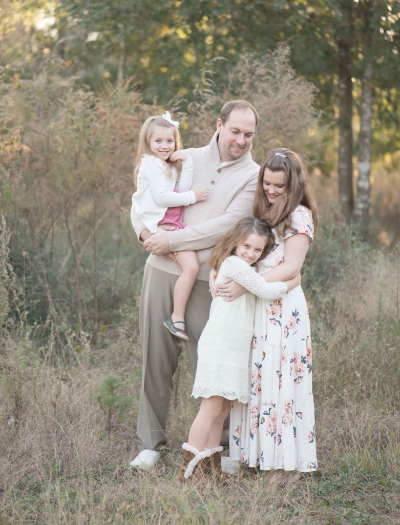 family with two little girls hugging mom and dad in The Woodlands, TX