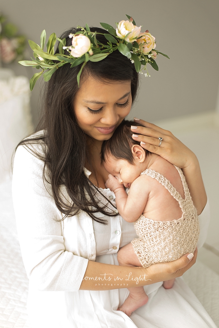 A mother wearing a crown holds her baby in a Houston photo studio. 