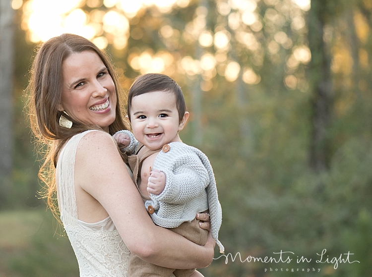 Mother holding baby son in a field by family photographer in The Woodlands