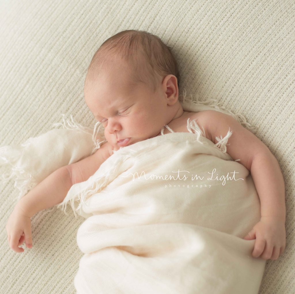 newborn baby on cream blanket in The Woodlands, TX