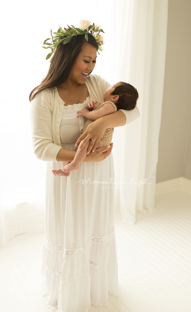 Moments in Light Photography captures a mother dancing with her baby in a bright room. 