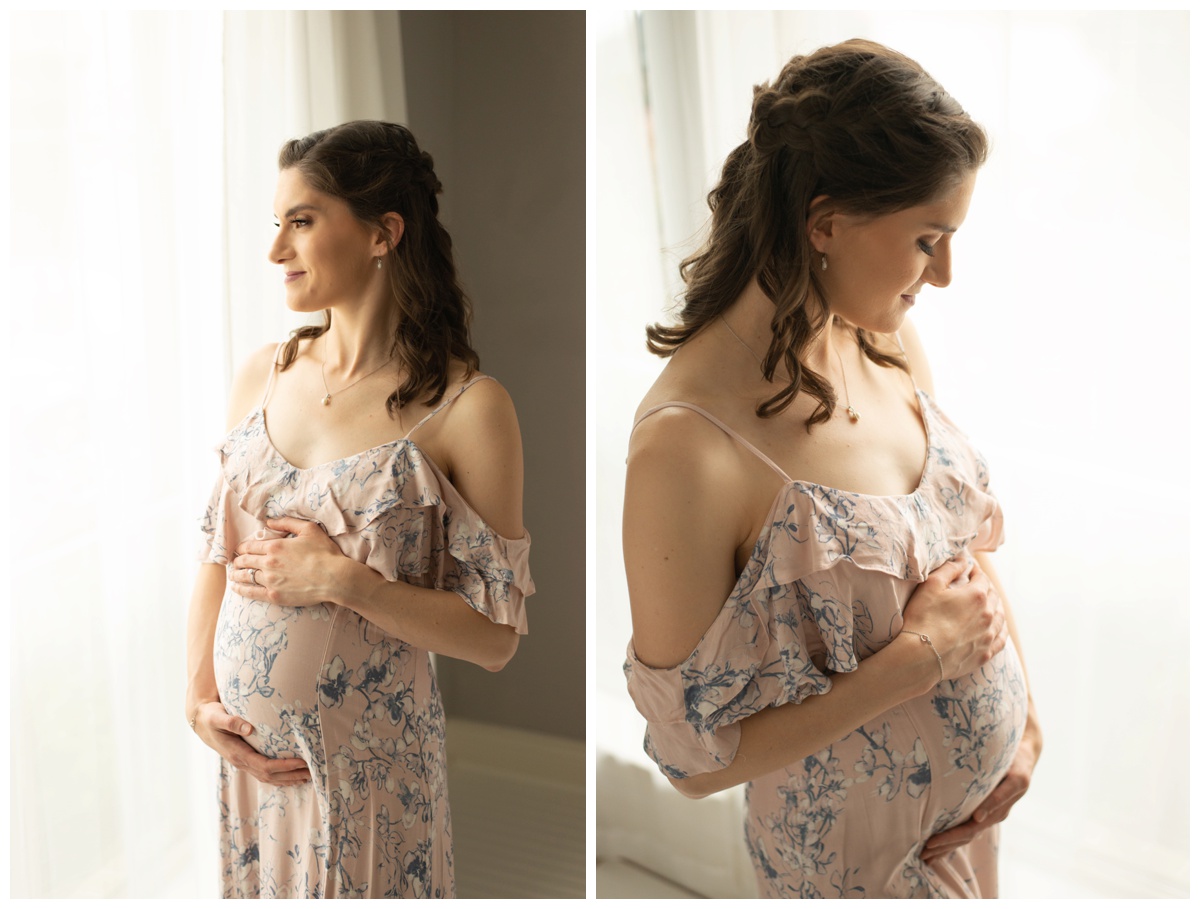 Maternity photo of woman in window of Houston photo studio wearing a pink floral dress