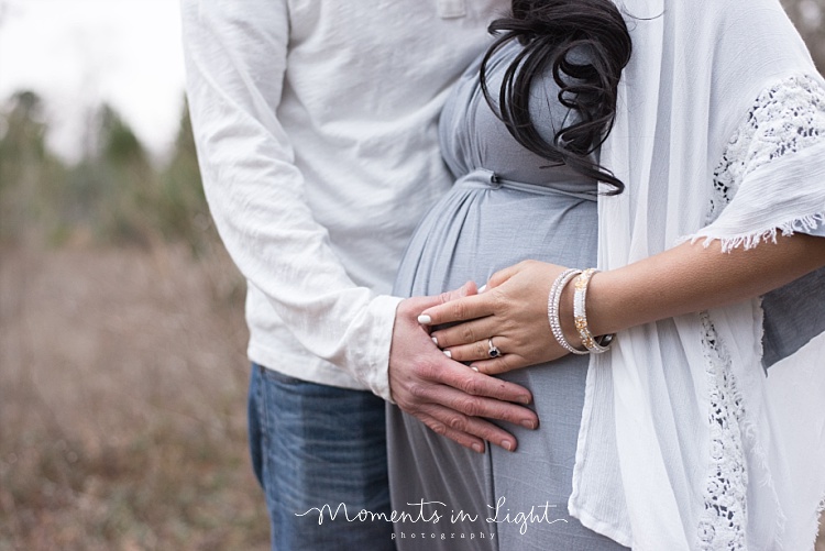 A man holds his wife's pregnant belly. 