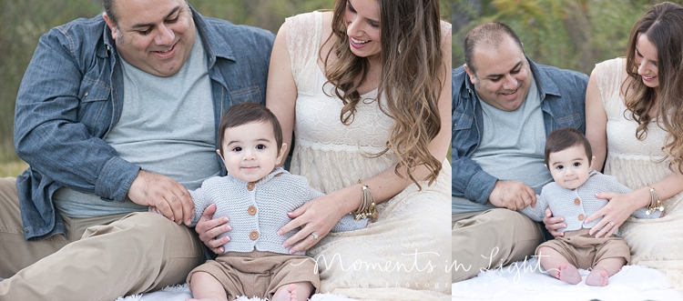 Baby boy sitting on a blanket in a field with parents by Houston family photographer 