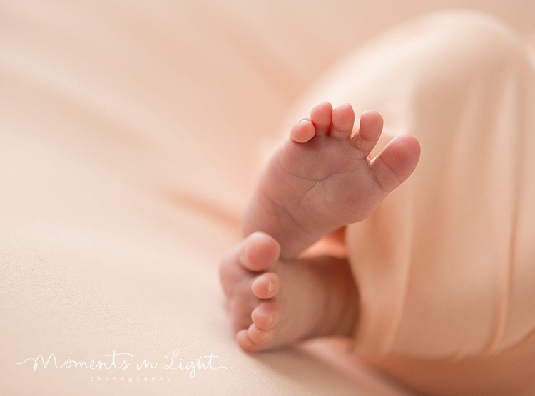 A newborn's toes wiggle free from the blanket she's swaddled in while she sleeps. 