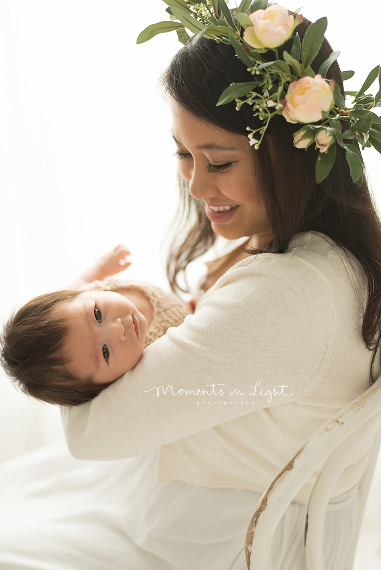 Moments in Light Photography captures a baby stretching in his mother's arms. 