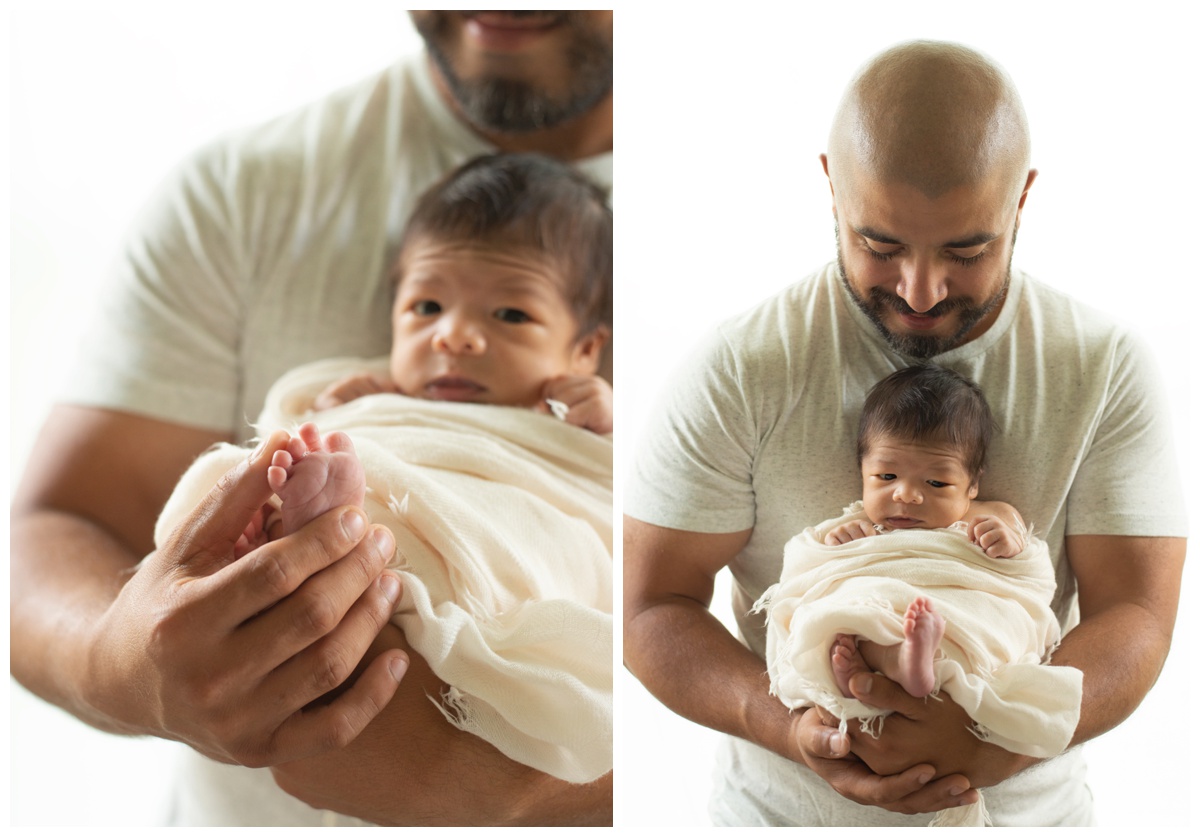 Father holding newborn and looking at baby's feet by Montgomery, Texas newborn photographer