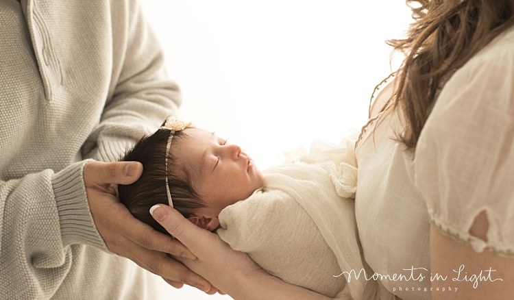 Two parents hold their new baby. 