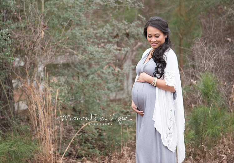 An expecting mother holds her belly for some outdoor maternity photos.