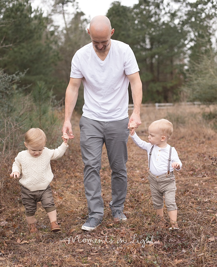 A father takes a walk with his twin baby boys. 