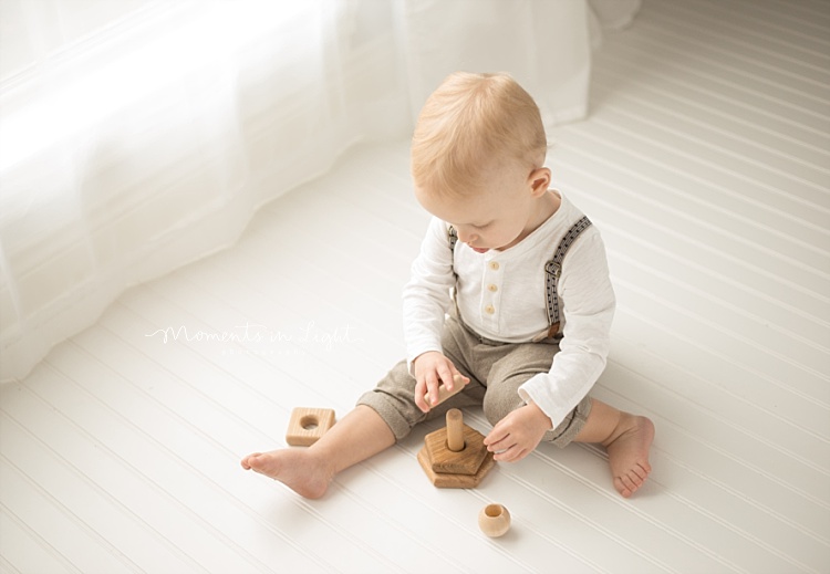 A little boy plays with some wooden toys. 