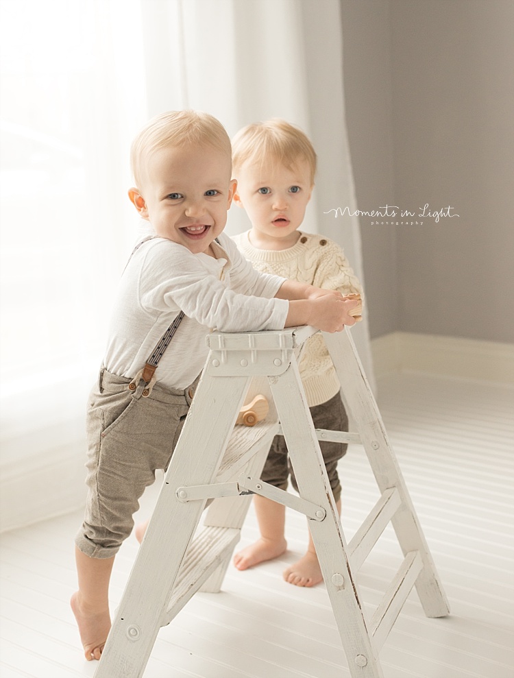 A toddler climbs on a ladder. 