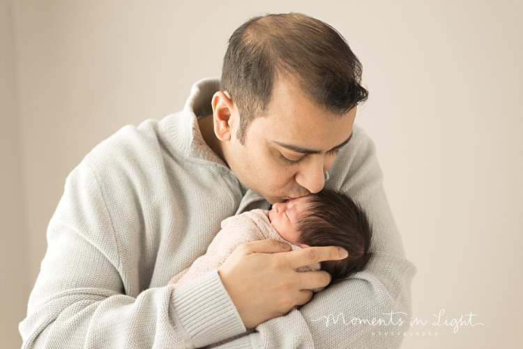 A father kisses his baby girl newborn. 