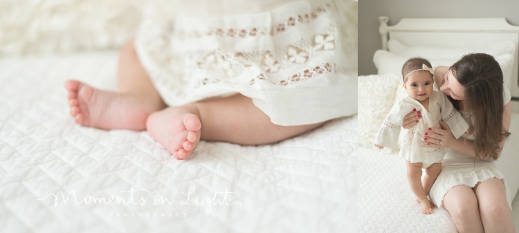 baby girl in white linen dress with mom on white bed in Houston photo studio 