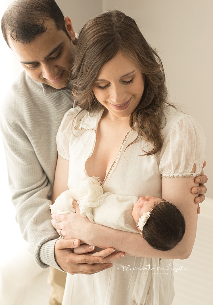 A man embraces his wife and new baby. 