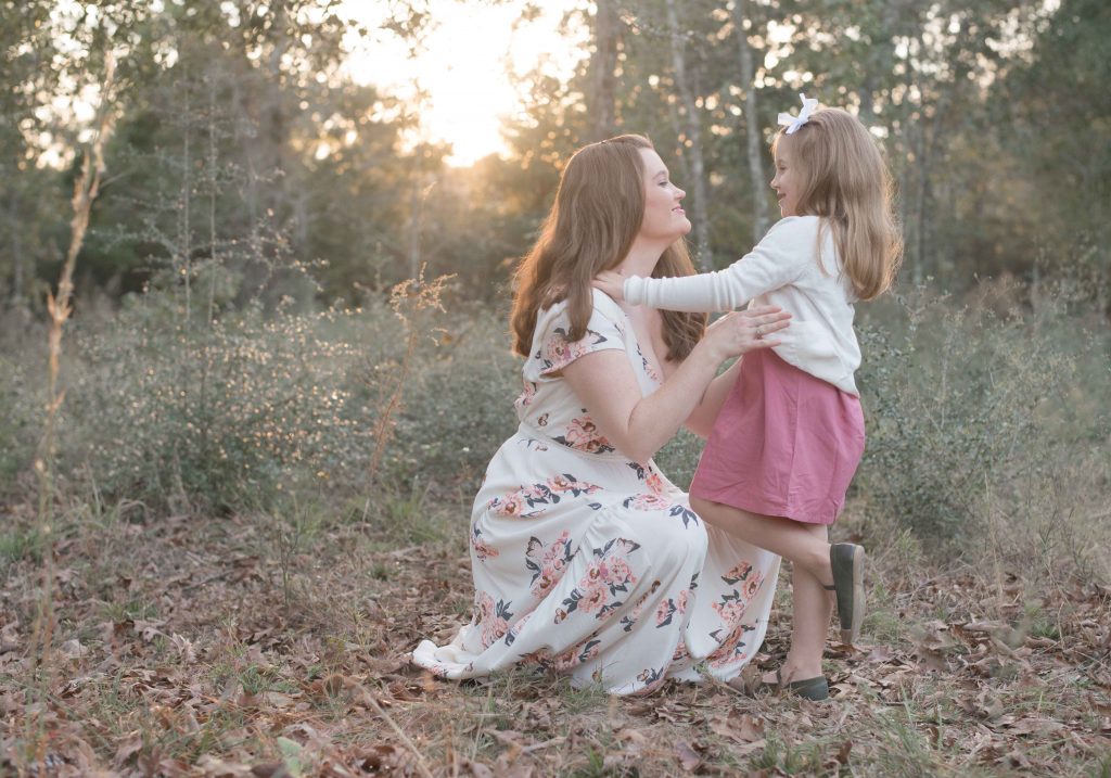 mom with little girl with sunset behind them in a field in Montgomery, TX