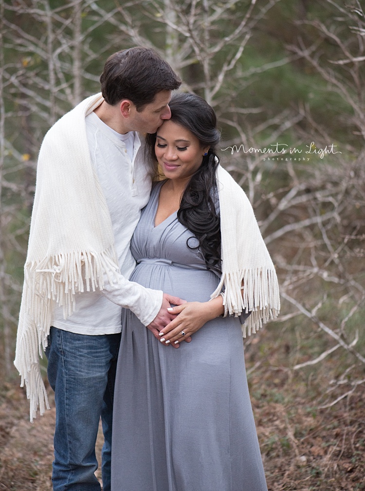 A man kisses his pregnant wife. 