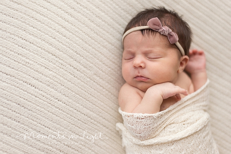 Baby girl wearing pink headband sleeping on bed by Montgomery, Texas newborn photographer