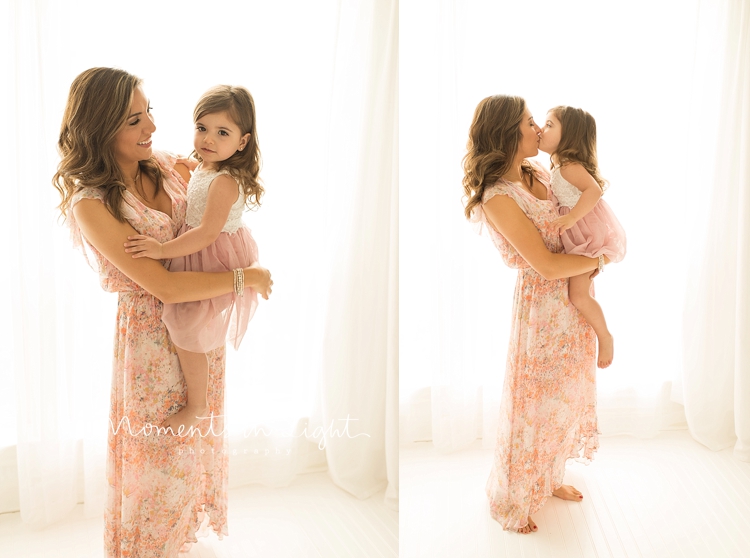 A mother kisses her daughter during a photo session with Moments In Light Photography. 