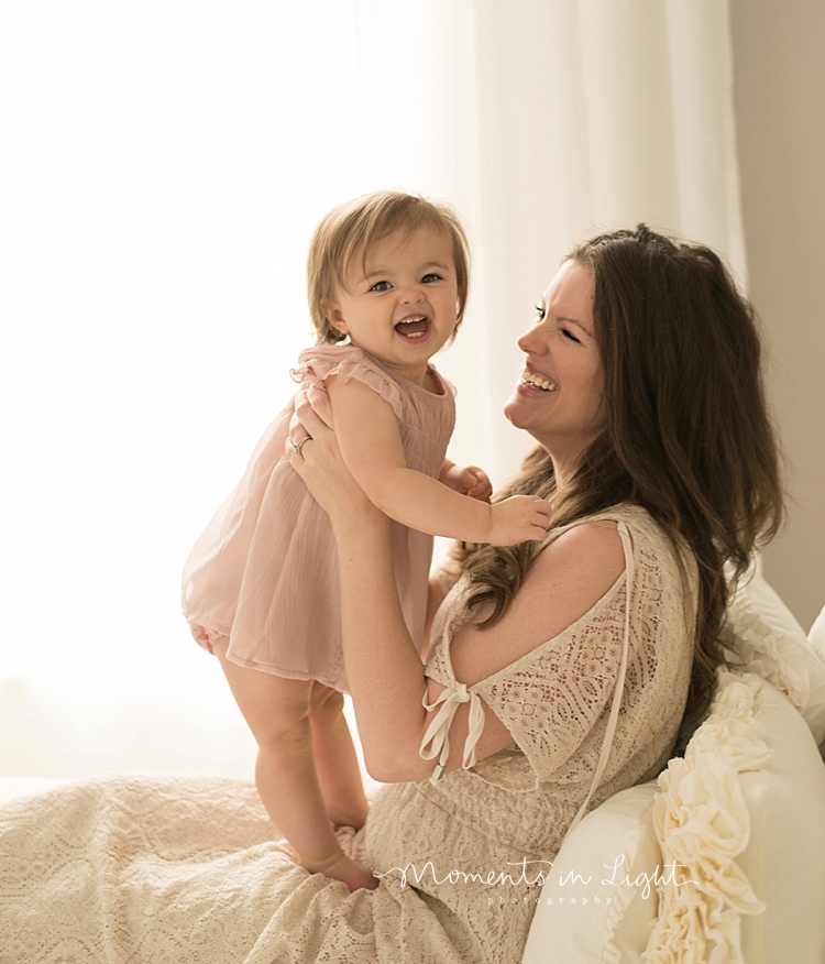 Baby photographer, Moments In Light Photography, captures a mother playing with her baby girl. 