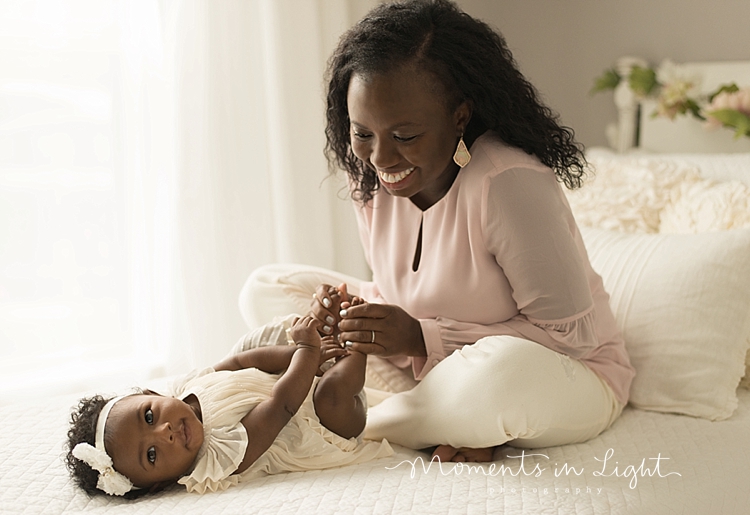 Moments in Light Photography captures a mother tickling her baby on a bed. 