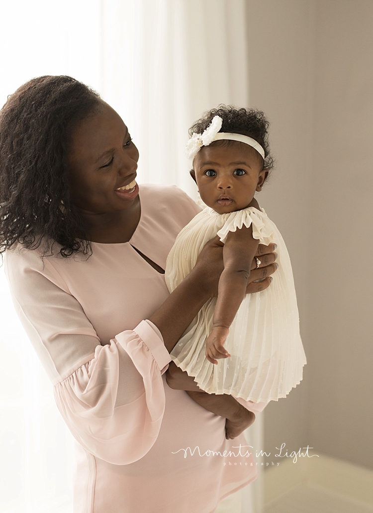 Mom holds her baby on her hip for a session with Moments In Light Photography. 