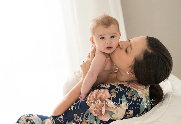 A mama kisses her baby on the cheek during a mommy and me session with Moments In Light Photography. 