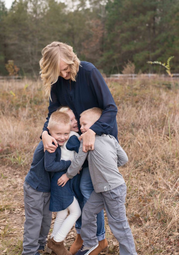 mom hugging her triplets in a field in Montgomery, TX