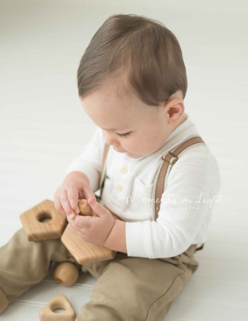 close up of baby boy's eyelashes as he plays with an organic wooden toy